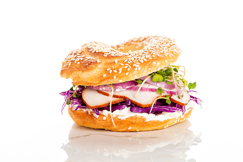 fresh delicious bagel with meat, red onion, cream cheese and sprouts on white background