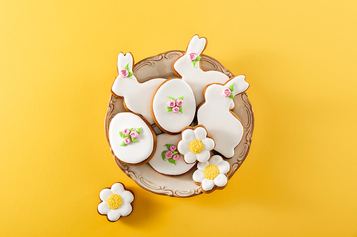 Top view of bowl with delicious cookies on yellow background