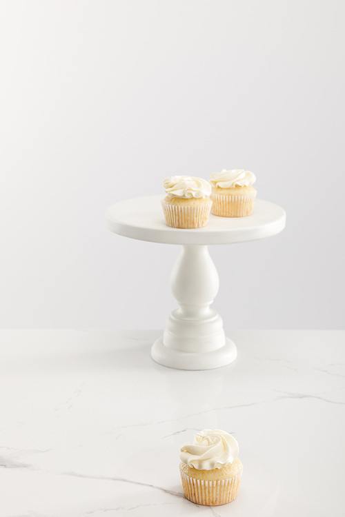 Tasty cupcakes on cake stand isolated on grey