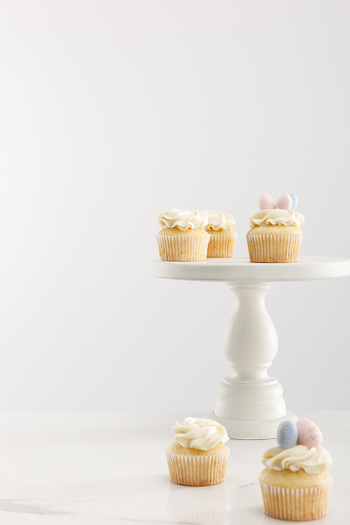Selective focus of cupcakes on cake stand isolated on grey