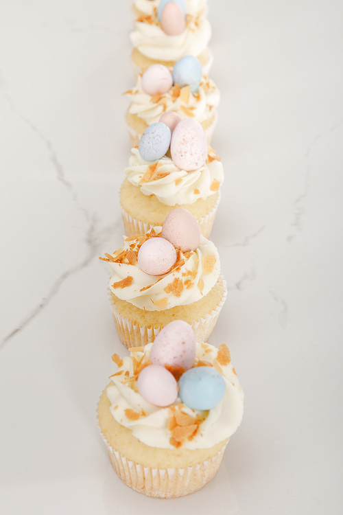 Selective focus of delicious easter cupcakes on white background