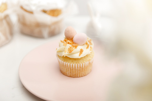 Selective focus of cupcake on plate on white background