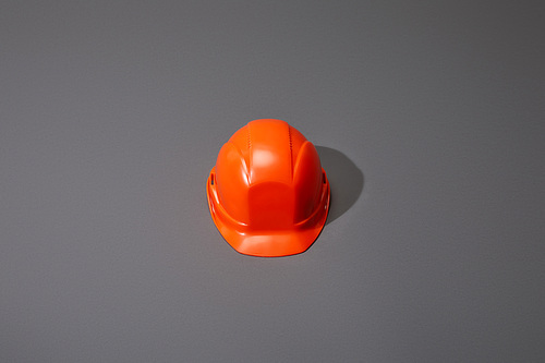 high angle view of orange helmet on grey background