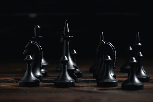 selective focus of chess figures on textured surface isolated on black