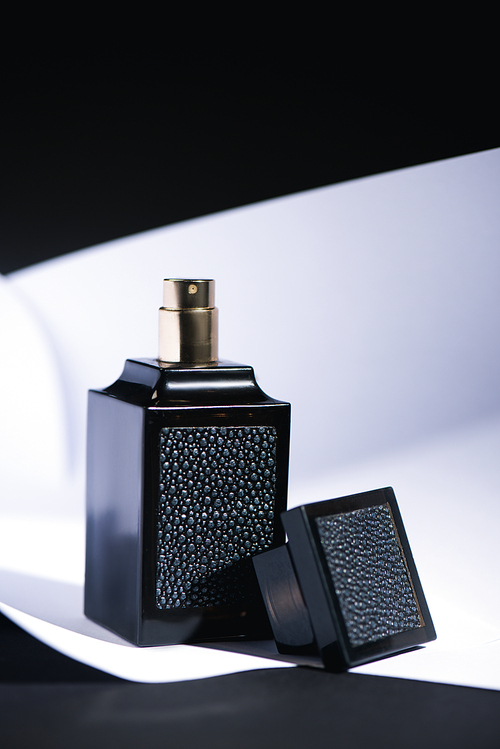 bottle with luxury perfume on white and black