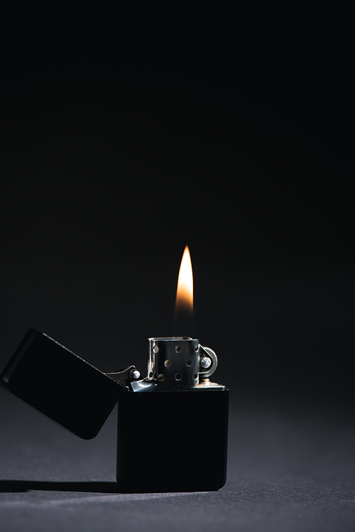 dark lighter with burning fire on black with copy space