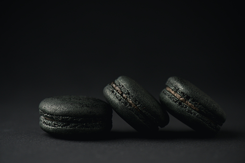 dark and tasty macarons on black with copy space