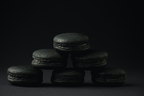 dark and delicious macarons on black with copy space