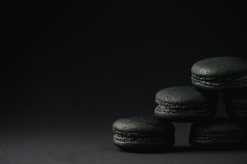 dark and sweet macarons on black with copy space