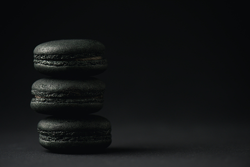 delicious and dark macarons on black with copy space