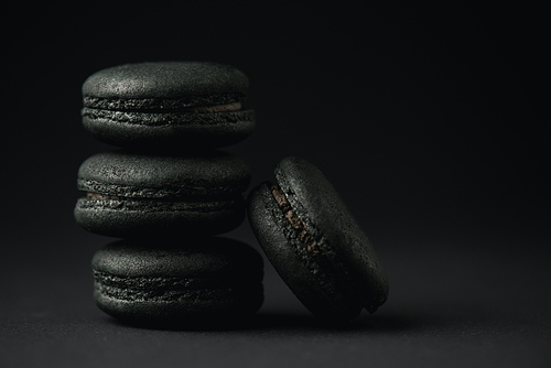 tasty and dark macarons on black with copy space