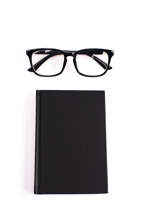 top view of glasses and black notebook isolated on white