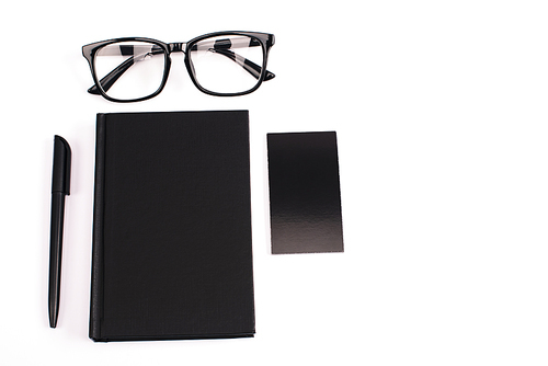 top view of notebook, pen, blank card and glasses isolated on white