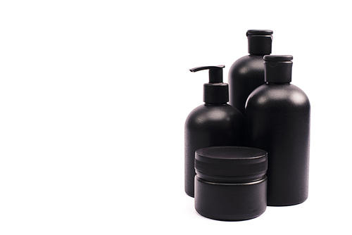 black container near bottles with body lotion isolated on white