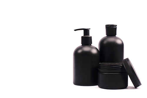 black container with face cream near bottles isolated on white