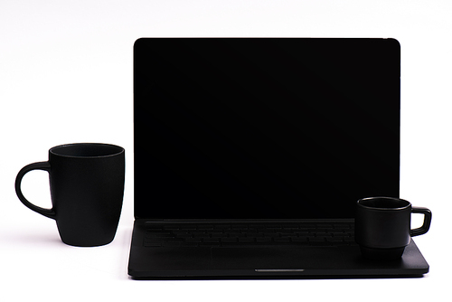 cups of coffee and black laptop with blank screen on white