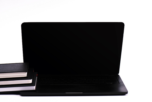 notebooks near black laptop with blank screen isolated on white