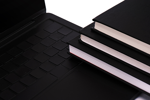 notebooks near black and modern laptop isolated on white