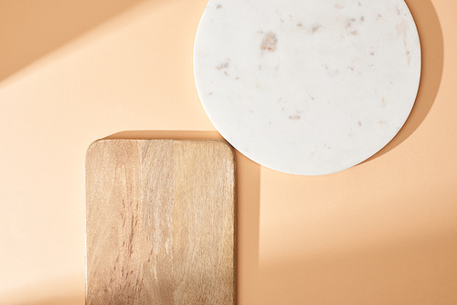 top view of wooden and marble boards on beige background