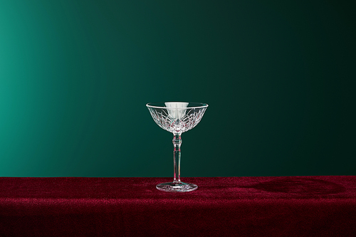 cocktail glass on red velour surface isolated on green