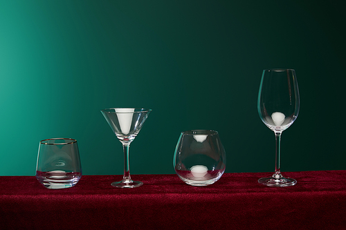 liqueur glass, cocktail glass, brandy glass and wine glass isolated on green
