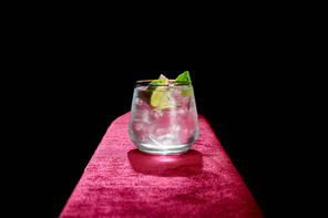 Old fashioned glass with fresh cold mojito, mint and lime slice isolated on black