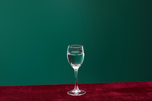 shot glass with pure transparent liquid isolated on green