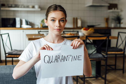 Attractive woman tearing card with quarantine lettering