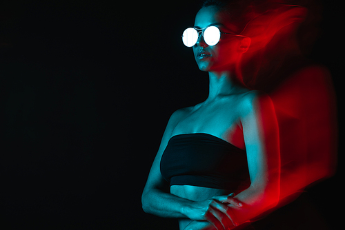motion blur of pretty woman in sunglasses on black