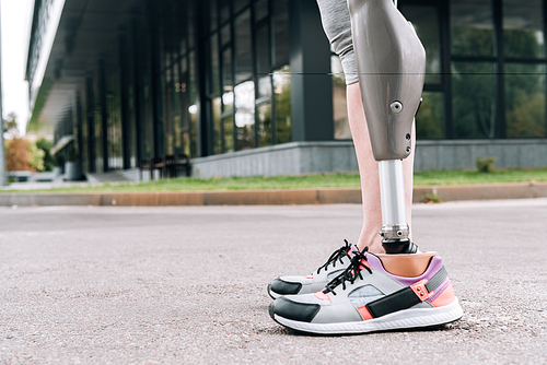 partial view of disabled sportswoman with prosthesis on street