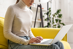 Cropped view of freelancer working on laptop at home
