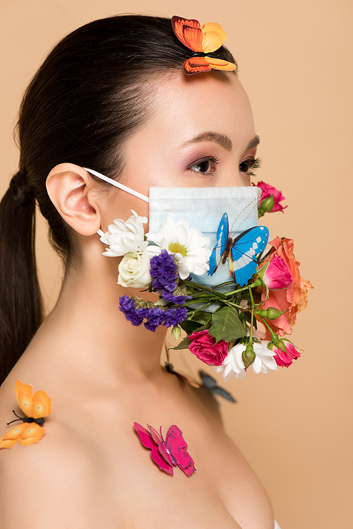 attractive asian woman in floral face mask with butterflies isolated on beige