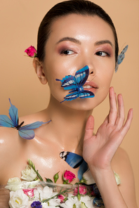 beautiful nude asian girl in flowers with butterflies on body isolated on beige