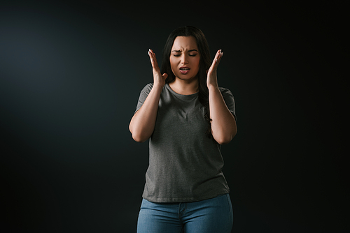Front view of angry plus size girl gesturing on black background