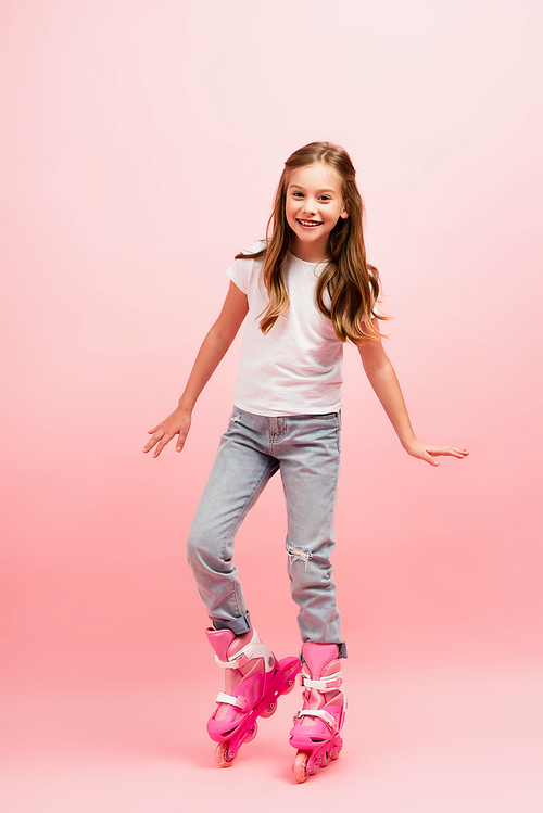 excited girl in white t-shirt, jeans and rolling skates  on pink