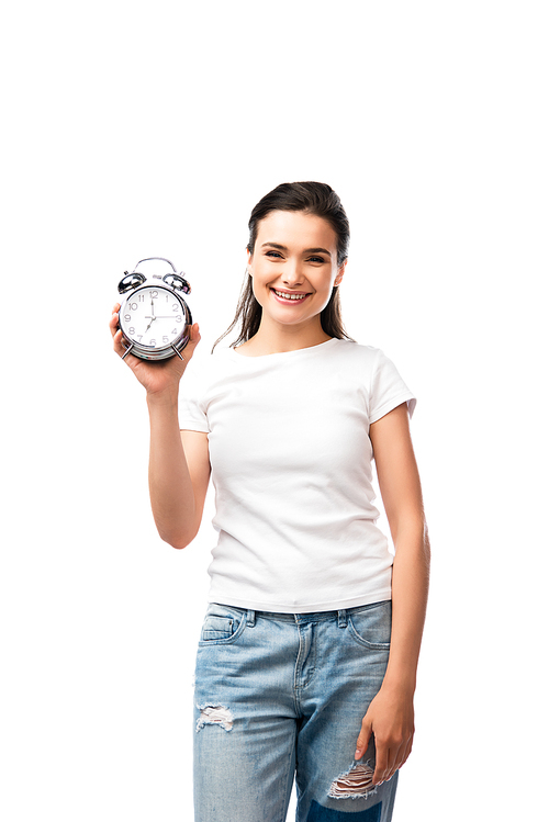 young brunette woman in white t-shirt and jeans holding retro alarm clock isolated on white