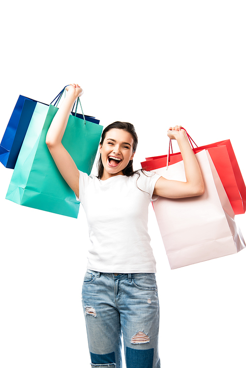 brunette woman with open mouth holding shopping bags isolated on white