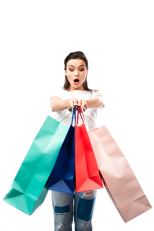 shocked woman looking at shopping bags isolated on white