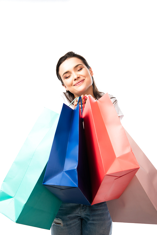 young brunette woman with closed eyes holding shopping bags isolated on white