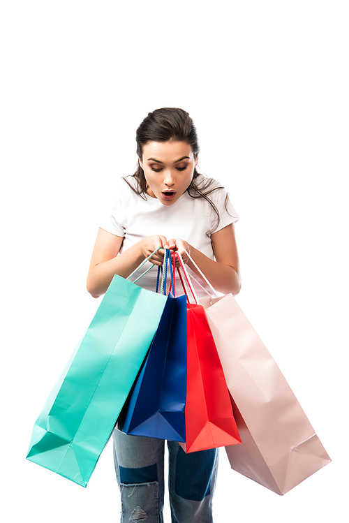 young shocked woman looking at shopping bags isolated on white