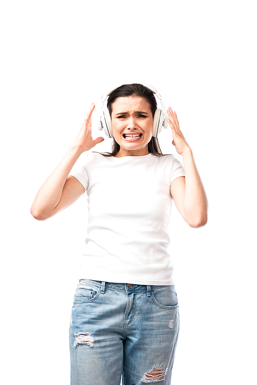 stressed young woman in white t-shirt and wireless headphones isolated on white