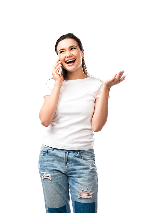 young woman in white t-shirt gesturing and talking on smartphone isolated on white