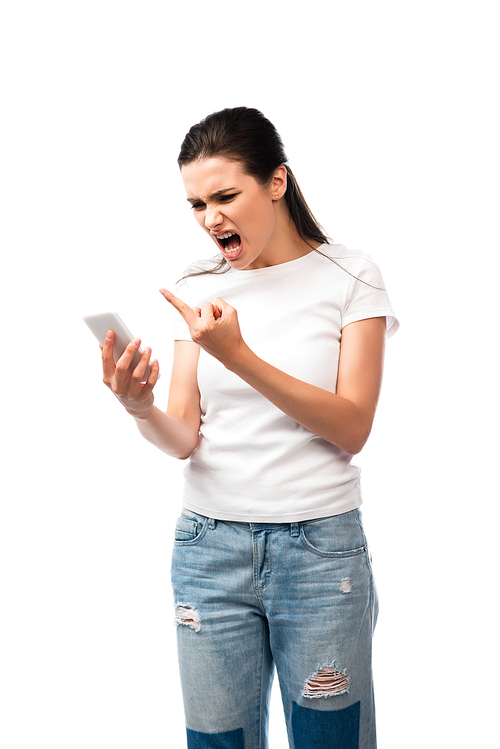 displeased woman screaming and showing middle finger while holding smartphone isolated on white