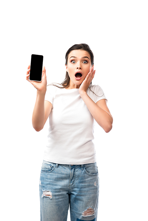 shocked woman in white t-shirt holding smartphone with blank screen isolated on white