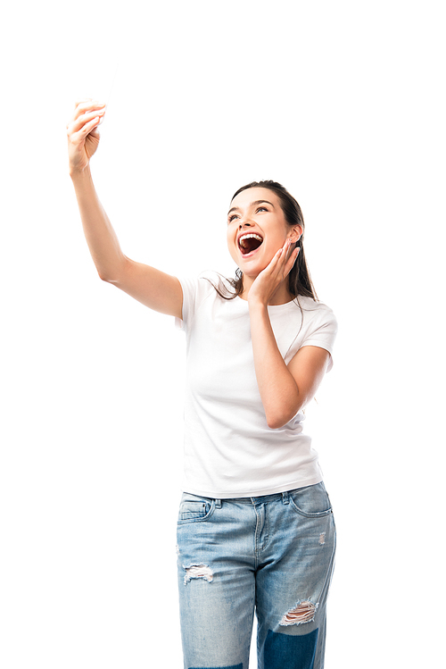 excited brunette woman in white t-shirt taking selfie isolated on white