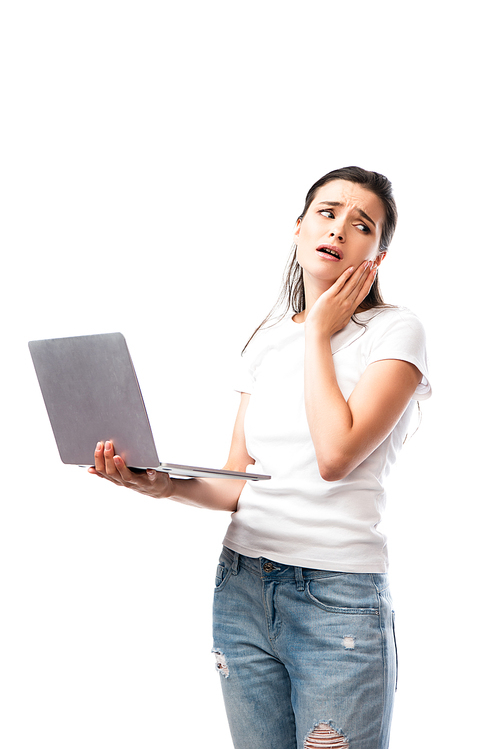 worried brunette woman in white t-shirt holding laptop isolated on white