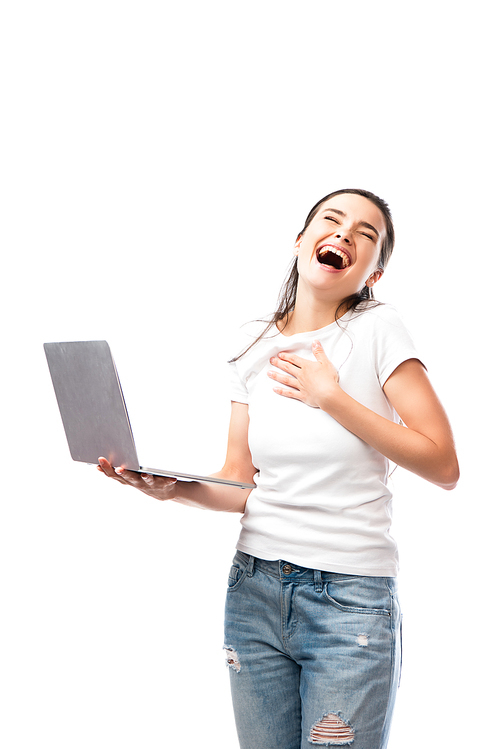 brunette woman in white t-shirt laughing and holding laptop isolated on white