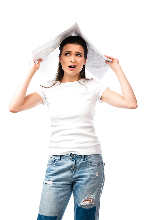 displeased brunette woman in white t-shirt holding newspaper above head isolated on white