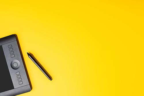 top view of drawing tablet and stylus on yellow