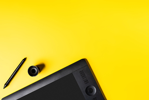 top view of modern drawing tablet, holder and stylus on yellow